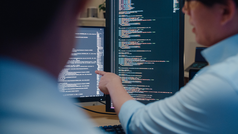 People analyzing code on a computer screen.